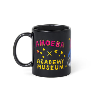 Black mug with colorful text and graphics on a white background Amoeba Records Los Angeles logo with the Academy Museum Store logo